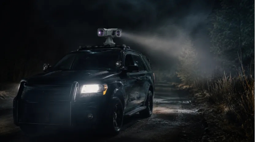 Rugged police vehicle with roof-mounted thermal PTZ camera scouting a dark roadside at night